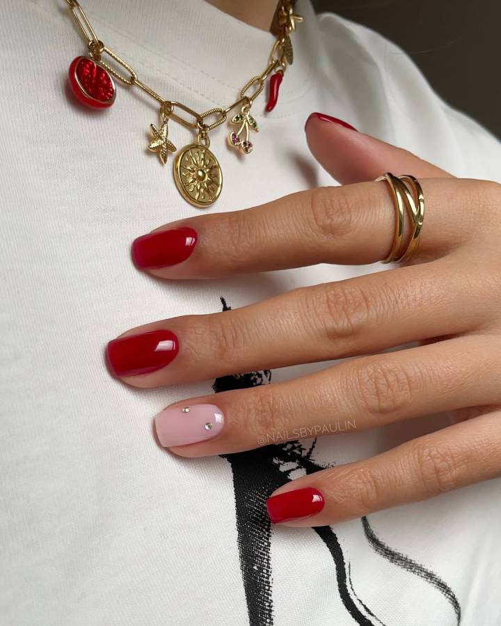 Unhas vermelhas com aplicação de adesivos delicados